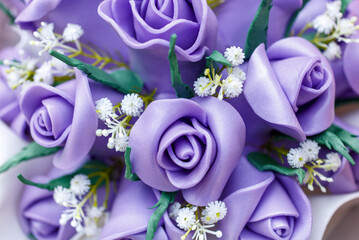 A bouquet of purple roses with white flowers