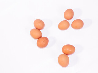 A collection of fresh brown eggs displayed on a clean white surface, highlighting the natural...