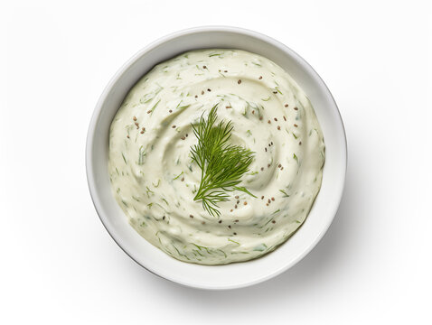 Overhead shot of creamy dill sauce in white bowl on a white background