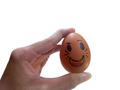 Hand holding an egg with a cute cat smiley face drawn on it, isolated on white background.