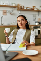 Young pretty woman enjoying a moment of tranquility while working at home in a cozy kitchen space