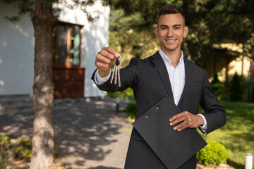 Real estate agent offering house keys and paperwork on clipboard in front of residential property
