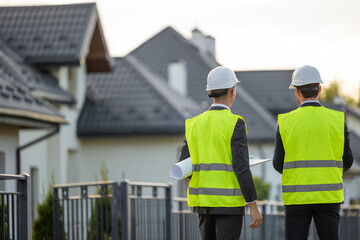 Construction team inspecting site with blueprints