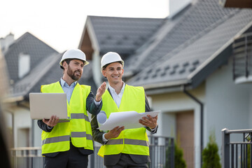 Construction team inspecting site with blueprints