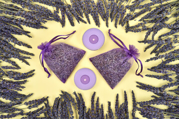 Lavender flowers and lavender products on the yellow background. Top view.