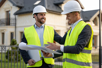 Builders analyzing plans outdoors