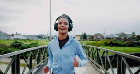 Running, fitness and woman with training, bridge and headphones for podcast, energy or wellness. Outdoor, person or runner with practice, cardio or streaming audio with workout, health or challenge - Powered by Adobe