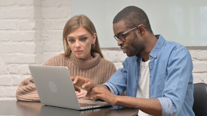 Young Casual People Discussing Online Project on Laptop