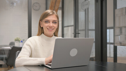 Excited Creative Young Woman Smiling at Camera at Workspace