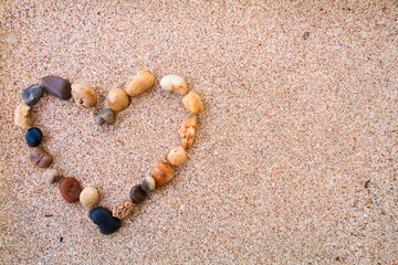 heart made of stones on sand