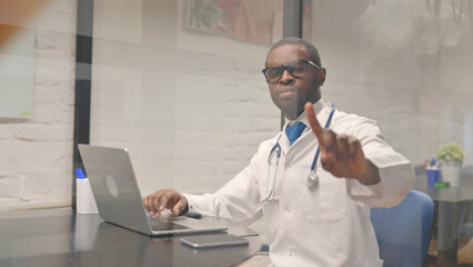Displeased African Male Doctor Denying while Looking at Camera