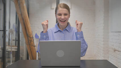 Young Woman Amazed by Success on Laptop