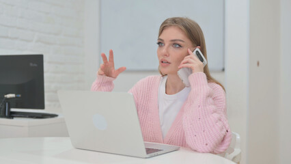Phone Talk with Customer by Creative Young Woman at Workspace