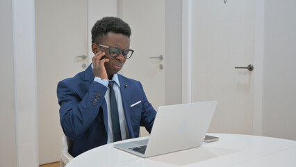 African Businessman Experiencing Ear Pain While Working