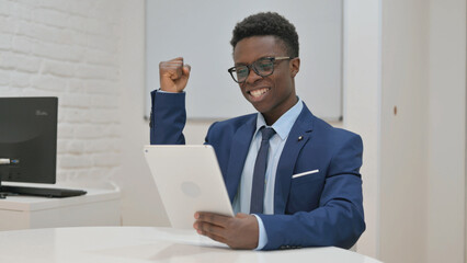 Young African Businessman Celebrating Success with Tablet