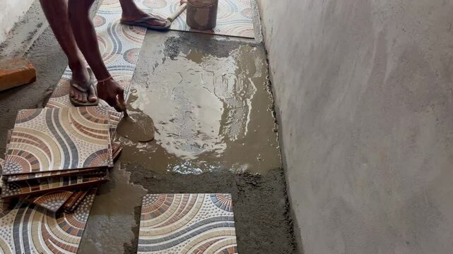 Applying Adhesive And Setting Floor Tiles In Place.
