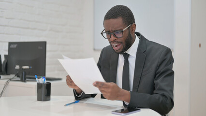 Businessman Expressing Shock or Disbelief While Reading Documents