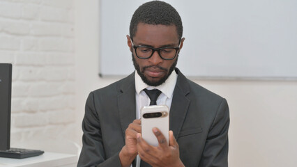 Focused Young African Businessman Using Smartphone