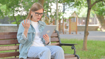 Young Woman Expressing Disbelief While Using a Tablet