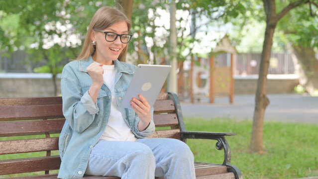 Young Woman Reacting with Surprise to Content on a Tablet