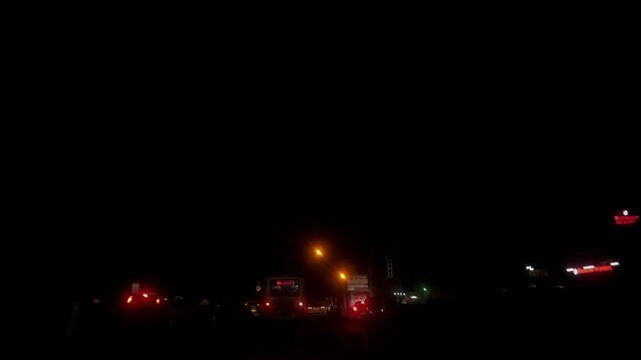 Vehicle Lights Glowing Through Car Front Window in Darkness.