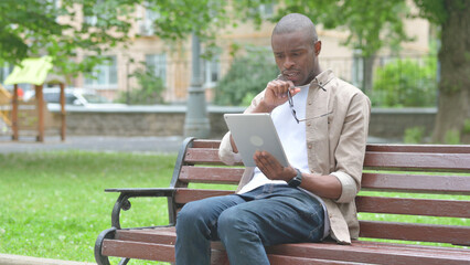 Obraz premium Young African Man Expressing Disbelief While Using a Tablet