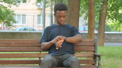 Waiting Casual African Man Checking Wrist Watch on Park Bench