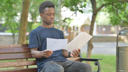 African American Man Reading Documents Outdoor