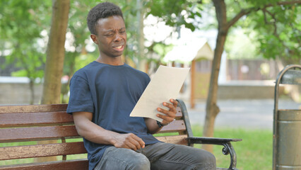 African American Man having Frustration While Reading Documents