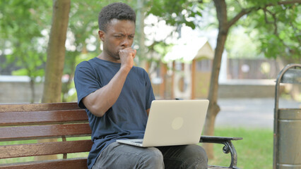 Coughing African American Man Using Laptop Outdoor