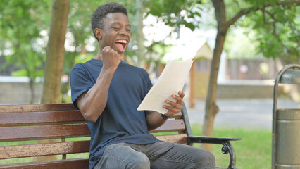 African American Man Excited by Reading Documents Outdoor