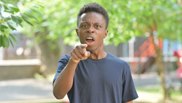 Angry Casual African Man Pointing and Scolding Outdoors