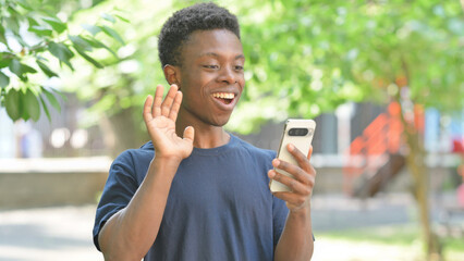 Talking Casual African Man Doing a Video Call Outdoors