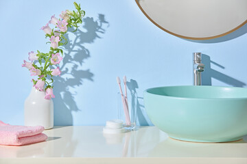 A round basin, vase with soft blooms and folded towels form a balanced Japandi bathroom. Clean...