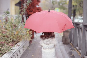 A girl with a red umbrella on an autumn walk