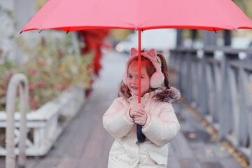 A girl with a red umbrella on an autumn walk