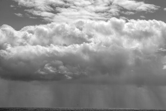 wolkenformation an der k&uuml;ste aus deren wolken es dicht regnet