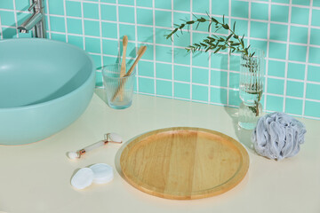 Clean beige counter in modern bathroom with green tiled wall, mint sink, toothbrushes and wooden...