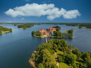 Aerial view of Trakai Island Castle in Lithuania with vibrant blue sky and serene lake
