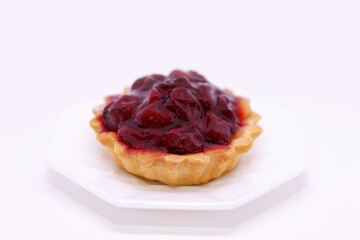 Delicious sweet dessert, cherry basket with cream and syrup lies on a dessert plate