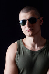 Naklejka premium Portrait of a Confident Man Wearing Sunglasses in a Dark Setting