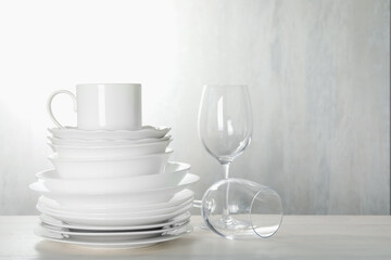 Different clean dishware on light wooden table indoors