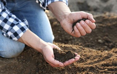 Man with pile of soil in field, closeup