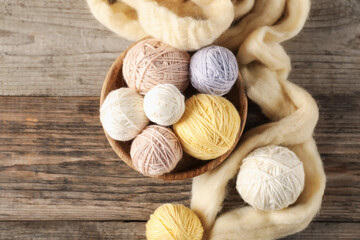 Felting wool and knitting yarn on wooden table, top view