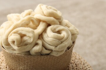 Felting wool and knitting yarn in wicker basket indoors, closeup. Space for text