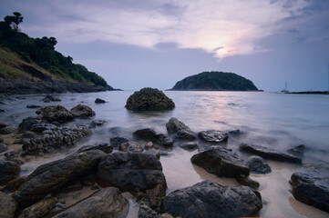 Idyllic Rocky Shoreline at Sunset With Distant Island and Smooth Waters