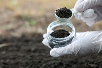 Scientist taking soil sample for research outdoors, closeup. Space for text