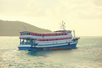 Vibrant coloured ferryboat nagiating through the bay near Samui in Thailand