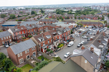 Aerial drone photo of the city of Leeds showing the area know as Harehills with rows of typical British West Yorkshire terrace houses and suburban British neighbourhood with parked cars on the street