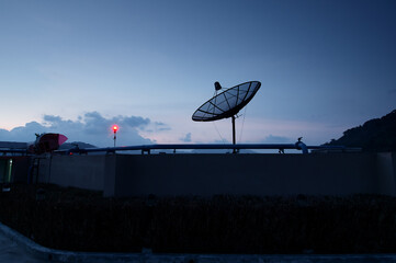 Satellite Dish With Scenic Sunset Sky Featuring Vibrant Colors and Urban Landscape